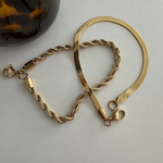 Freigestelltes Twist Armband in Gold aus Edelstahl mit Karabinerverschluss.