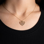 Nahaufnahme der Unique Heart Halskette in Gold mit filigranem Zirkonia-Herzanhänger am Hals.