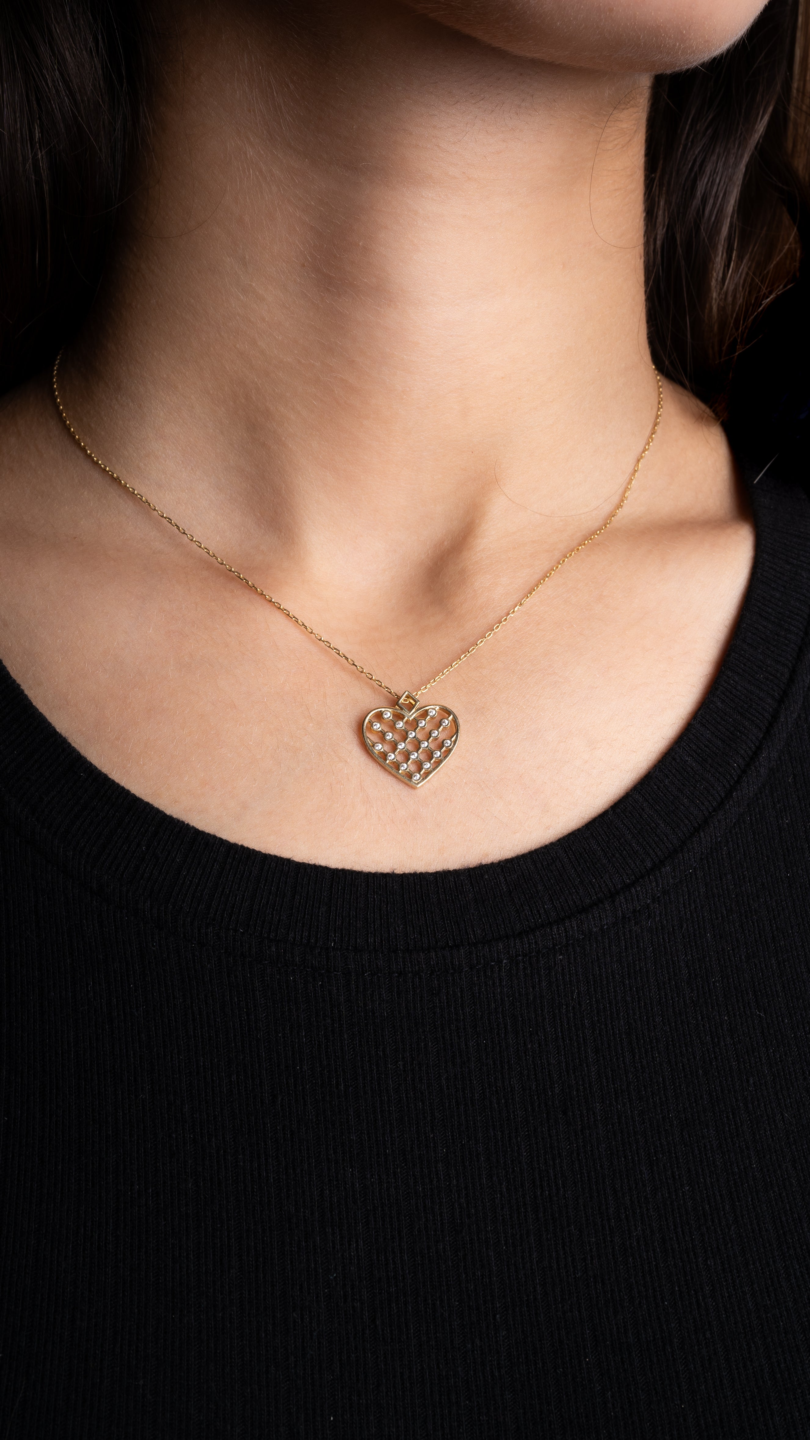 Nahaufnahme der Unique Heart Halskette in Gold mit filigranem Zirkonia-Herzanhänger am Hals.