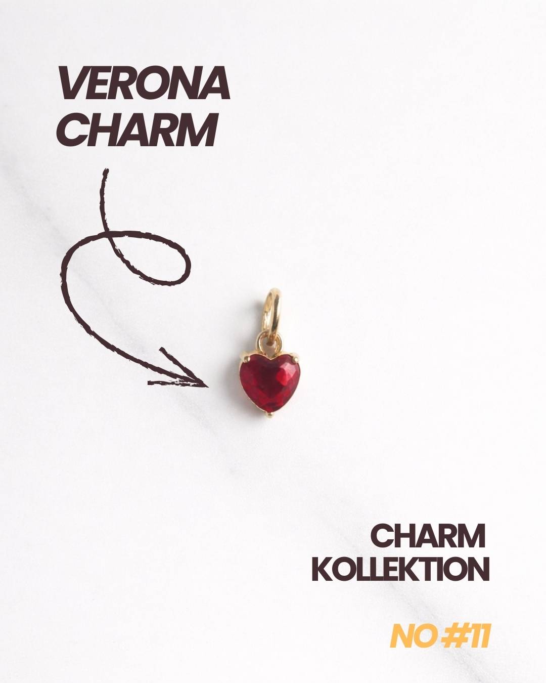Produktbild Verona Charm: goldener Herz-Charm mit rotem Stein, Schriftzug „Verona Charm“ und Pfeil.