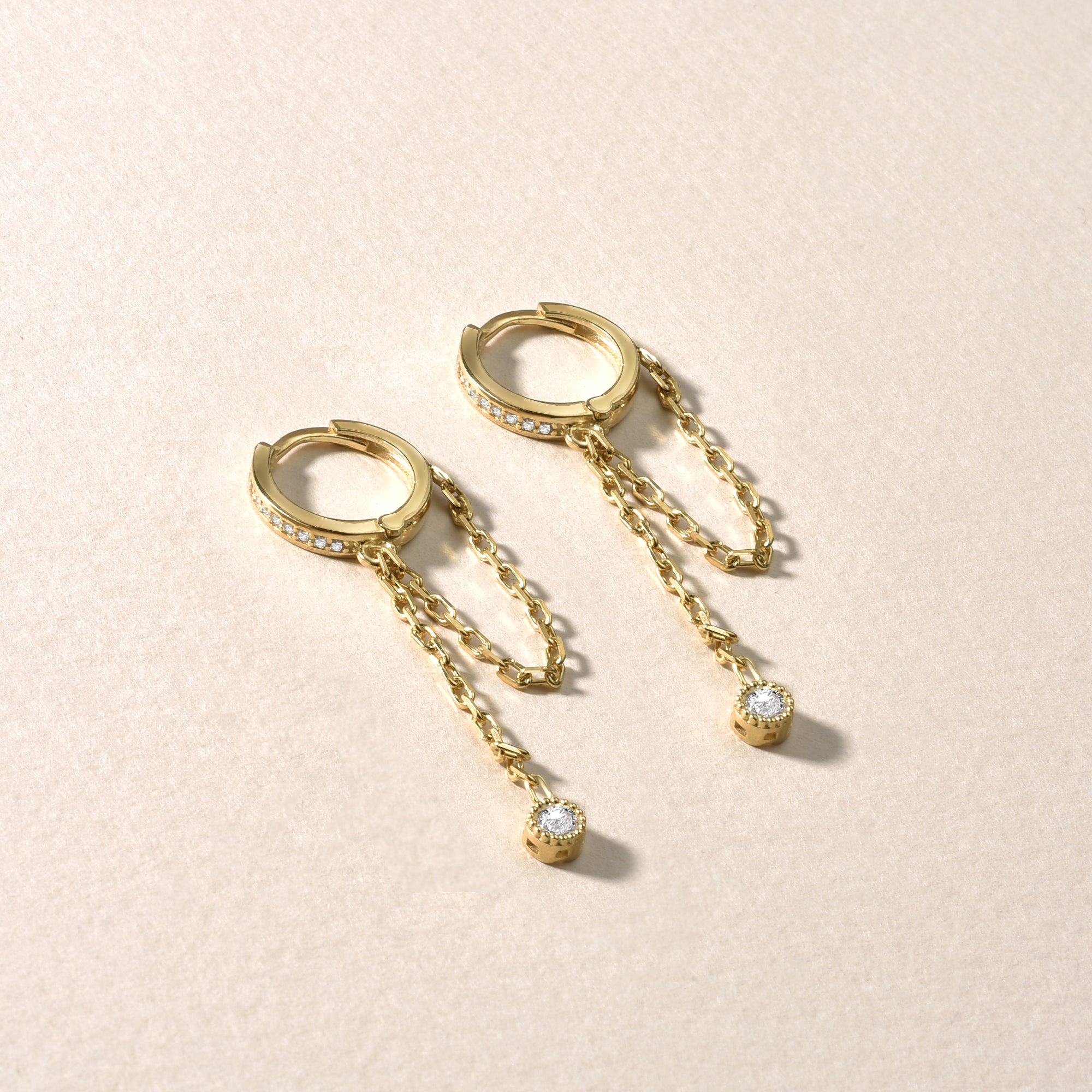 Detailaufnahme goldene Hängecreolen mit weißen Zirkonia, 925 Sterling Silber vergoldet, filigranes Schmuckdesign