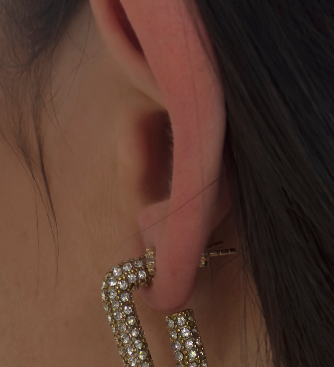 Eckiger Zirkonia Hoggie in Gold aus Edelstahl am Ohr getragen, pavé-besetzt, moderne U-Form.
