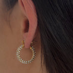 Detailansicht goldene Zirkonia-Huggie-Creole am Ohr, runde Pavé-Fassung, elegant und wasserfest.