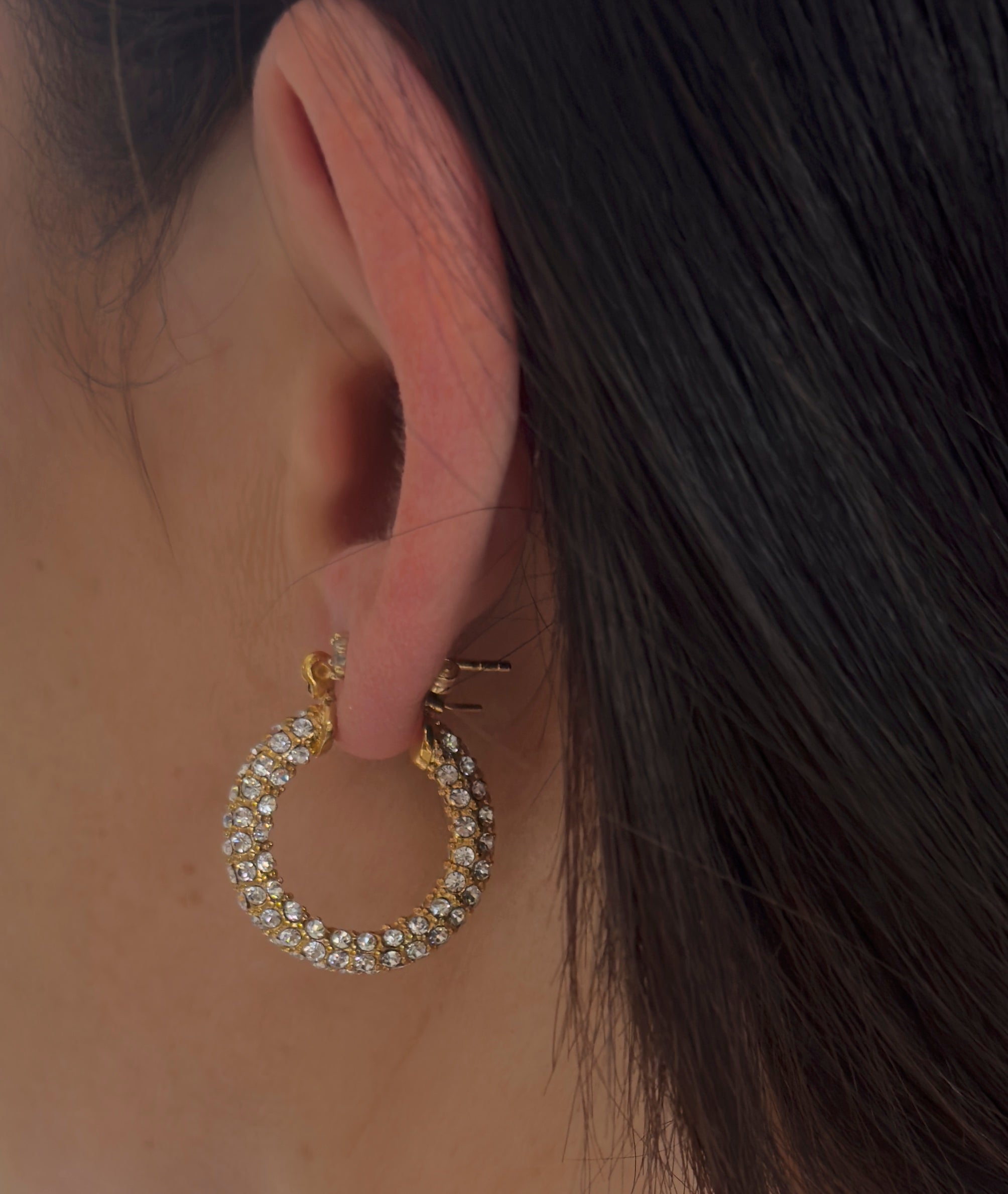 Detailansicht goldene Zirkonia-Huggie-Creole am Ohr, runde Pavé-Fassung, elegant und wasserfest.