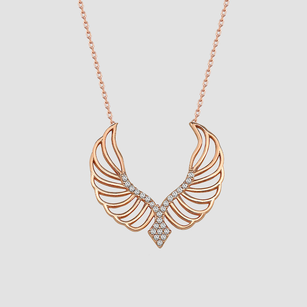 Angel Wings Halskette in Rosé mit funkelnden Zirkonia-Flügeln auf heller Fläche.