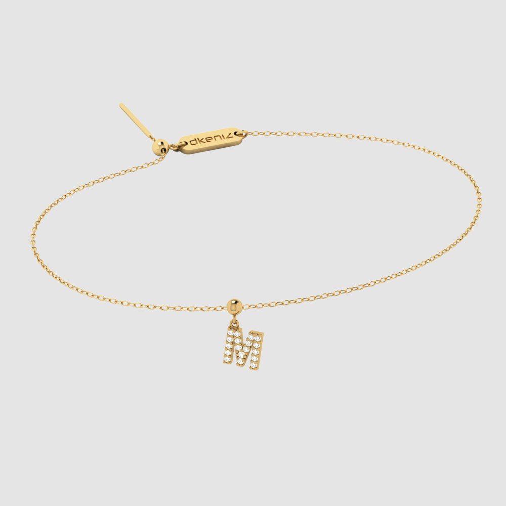 Zartes Goldarmband mit Buchstaben M Zirkonia Anhänger und Dkeniz Gravurplättchen.