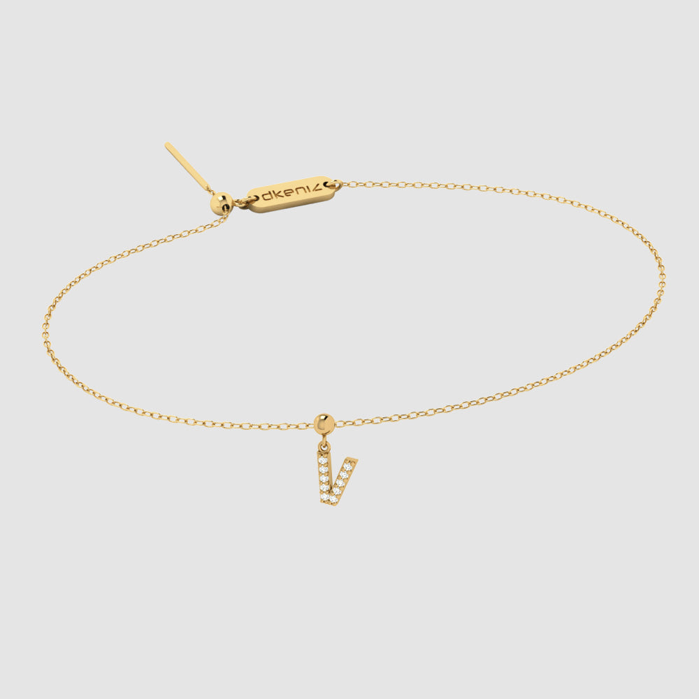 Zartes Goldarmband mit Buchstaben V Zirkonia Anhänger und Dkeniz Gravurplättchen.