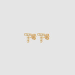 Goldene Buchstaben Ohrstecker T mit weißen Zirkonia-Steinen, Paar auf hellem Hintergrund.