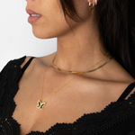 Model mit Butterfly Halskette und Gold-Choker, stilvoll geschichteter Halsketten-Look für Damen.