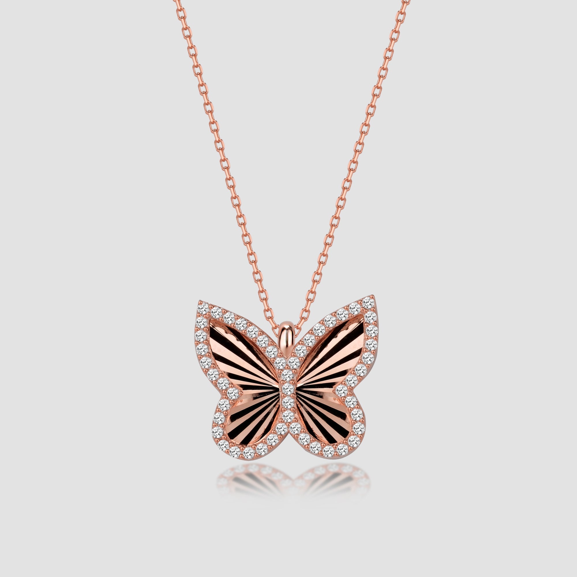 Butterfly Shiny Halskette in Rose mit Zirkonia, schimmernder Schmetterlingsanhänger auf neutralem Hintergrund.