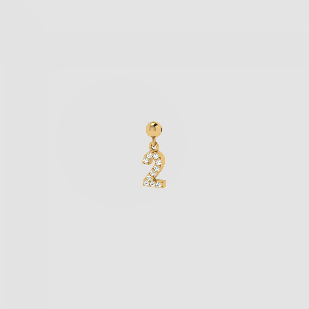 Goldener Charm Numbers Anhänger Zahl 2 mit weißen Zirkonia auf hellem Hintergrund.