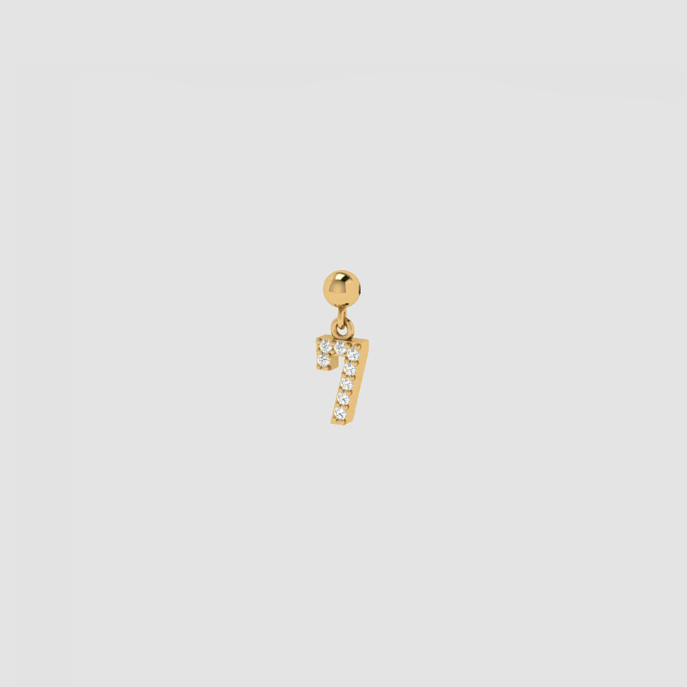 Goldener Charm Numbers Anhänger Zahl 7 mit weißen Zirkonia auf hellem Hintergrund.