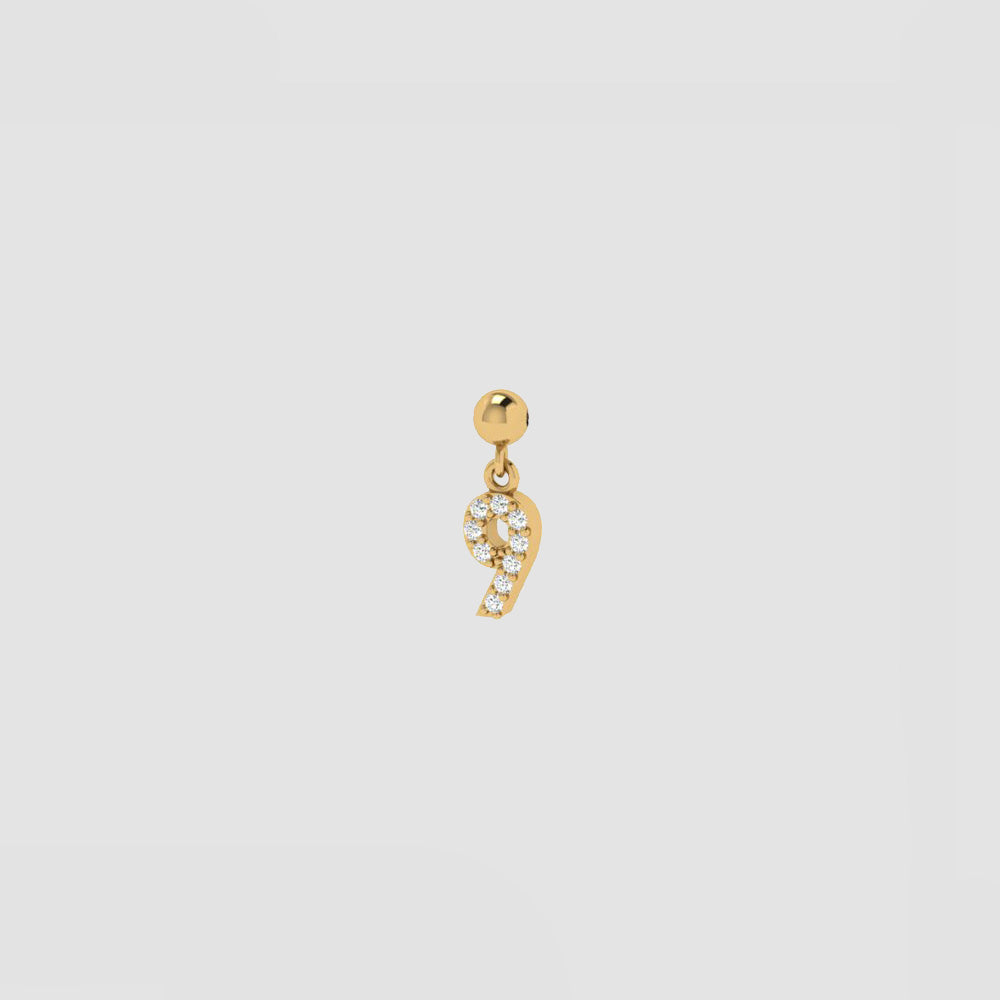 Goldener Charm Numbers Anhänger Zahl 9 mit weißen Zirkonia auf hellem Hintergrund.