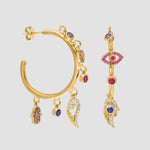 Detailaufnahme goldene Creolen mit Anhängern, Evil-Eye-Charme und Zirkonia Mix-Colors.