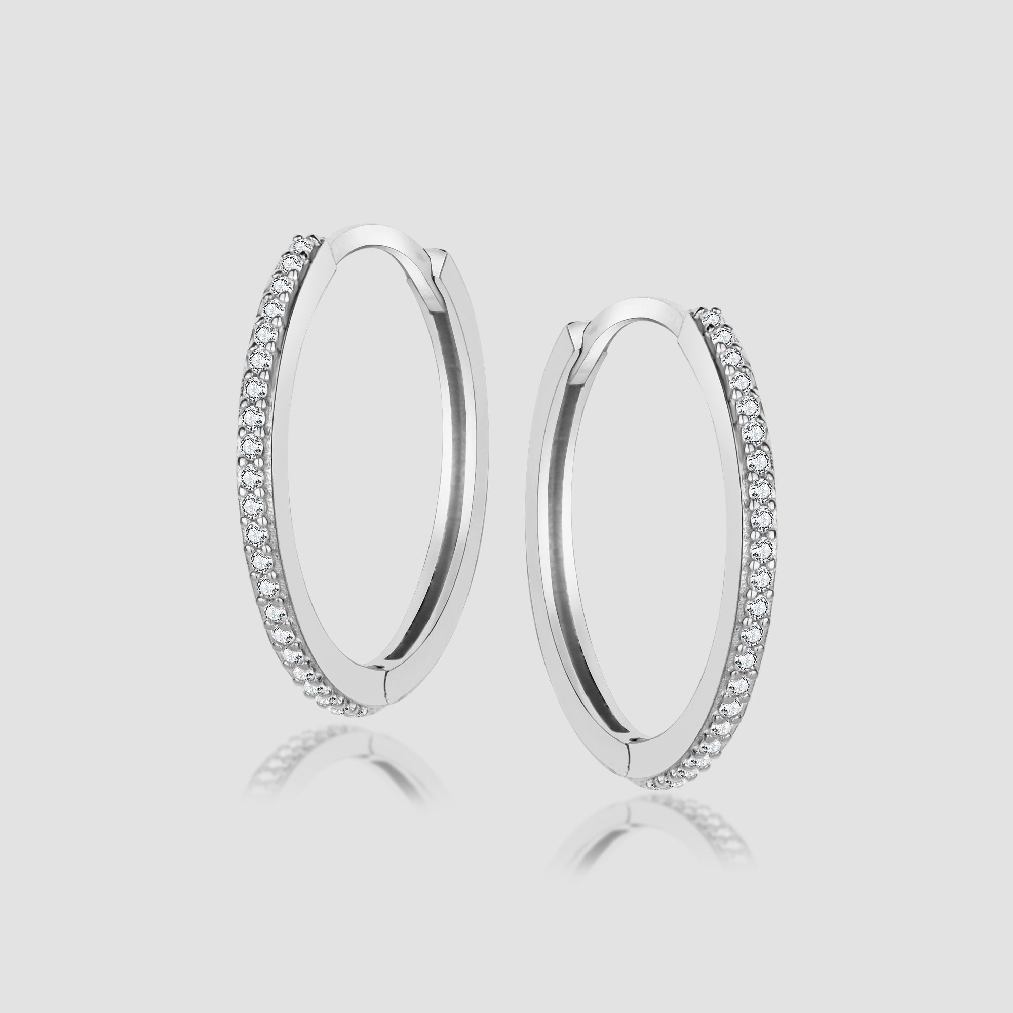 Silberne Creolen ONE Line Pavé L mit weißen Zirkonia-Steinen, Paar auf hellem Hintergrund.