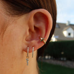 Getragener CROSS CLASSIC EAR CUFF am Ohr, kombiniert mit funkelnden Creolen und Ohrsteckern.