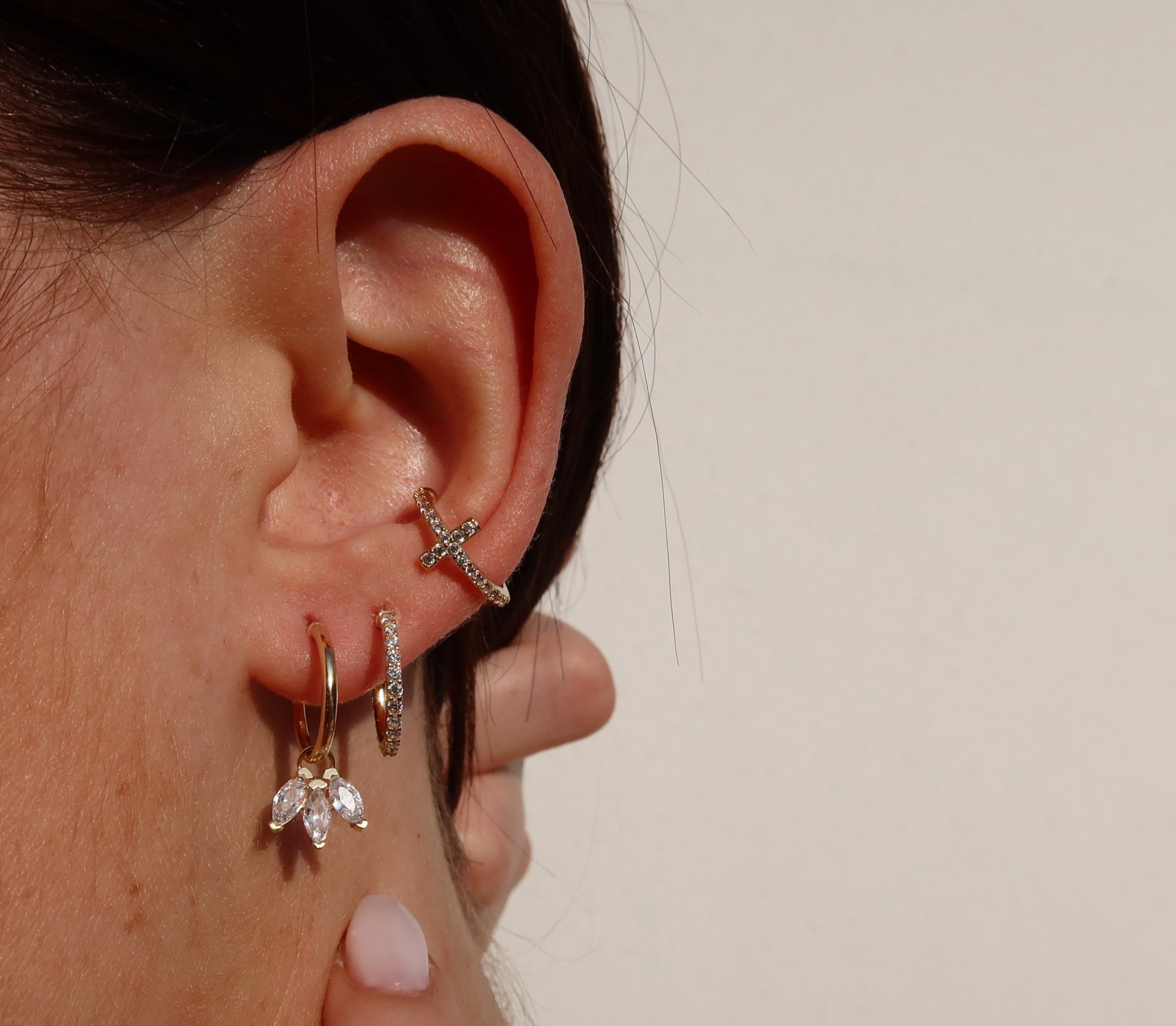 Rosé CROSS PAVE Ear Cuff mit Zirkonia am Ohr, kombiniert mit goldenen Creolen von Dkeniz.