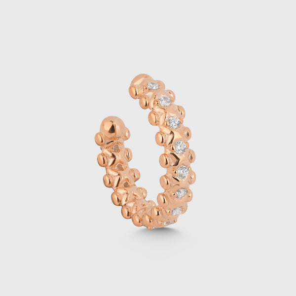 Detailansicht CRUSH EAR CUFF Rosé mit funkelnden Zirkonia-Steinen, strukturierte Oberfläche vor hellem Hintergrund.
