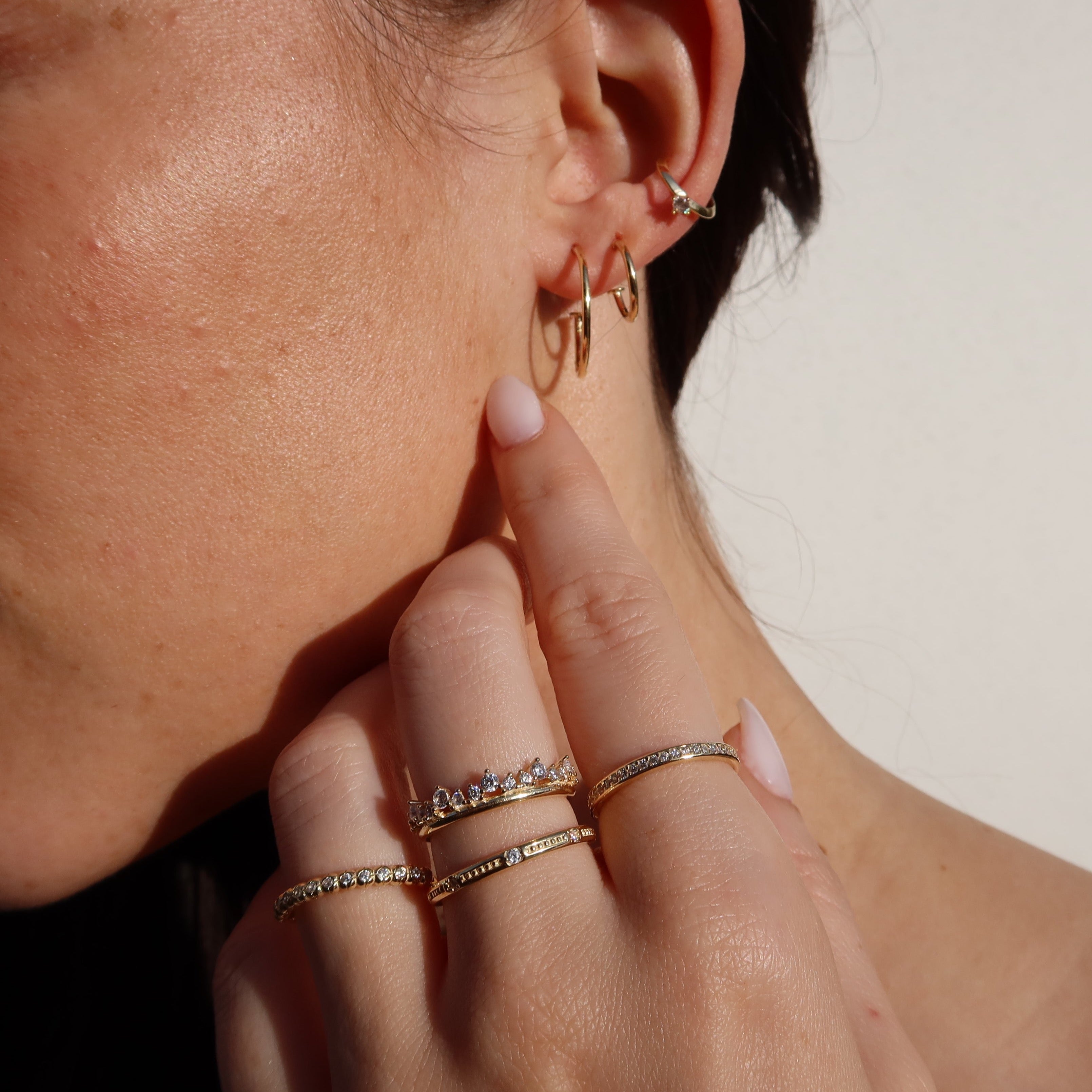 Close-up mit Diadem Ring und feinen Goldringen – zarter Zirkonia Ring am Finger.