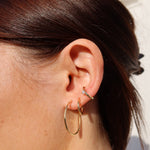 Kleine, schlanke Creolen am Ohr – eleganter Everyday-Schmuck in klassischem Design.