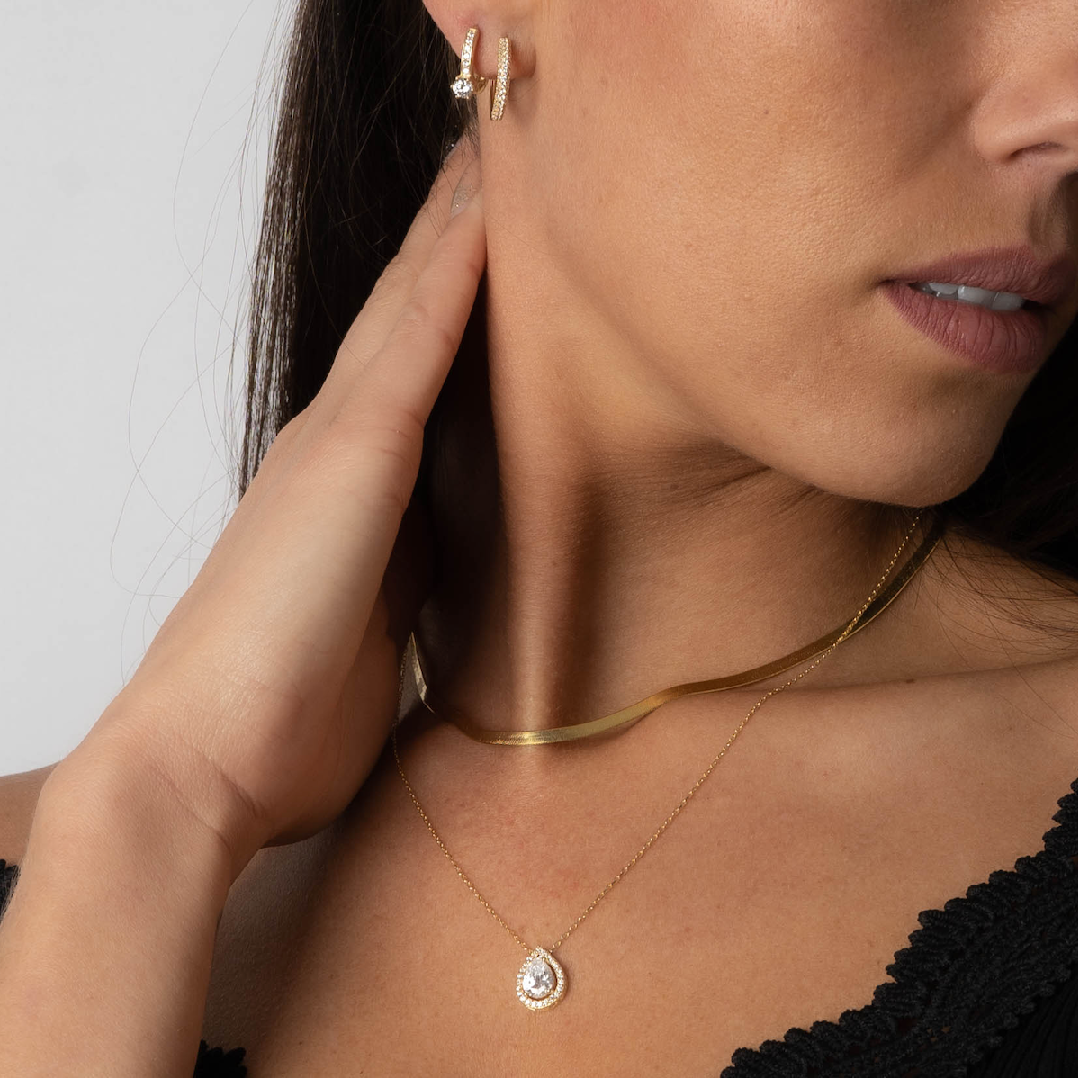 Drops Halskette Gold mit Zirkonia Steinen am Hals getragen, elegantes Layering mit weiterer Kette.