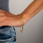 Rosefarbene FIGARO Armkette am Damenhandgelenk, getragen zu Jeans und lässigem Oberteil.