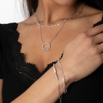 FIGARO Armkette M kombiniert mit Halsketten an Damenhandgelenk, eleganter Look in Schwarz.