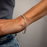 Silberne FIGARO Armkette M nah am Handgelenk, schlichtes Styling mit Top und Jeans.