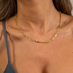 Feine FIGARO Kette S Gold dicht am Hals einer Frau, detailreicher Close-up.