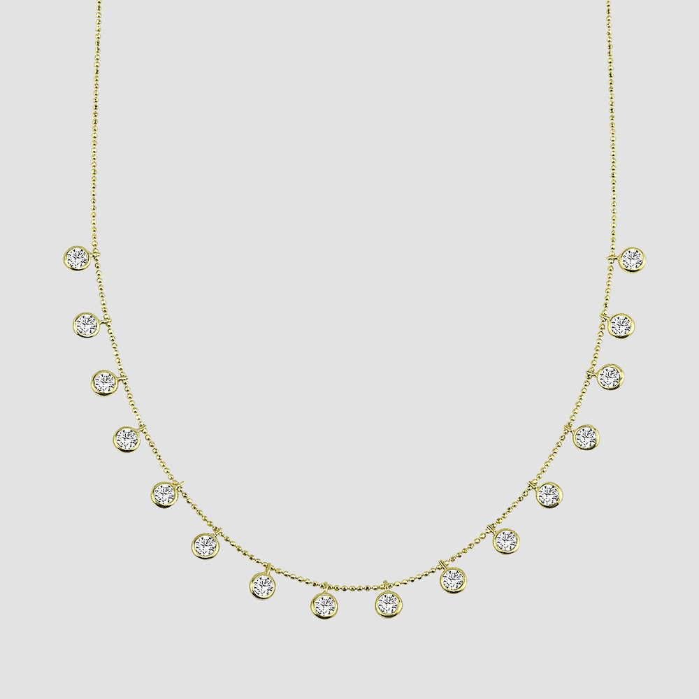Funkelnde Halskette in Gold mit weißen Zirkonia-Anhängern, Produktfoto auf hellem Hintergrund.