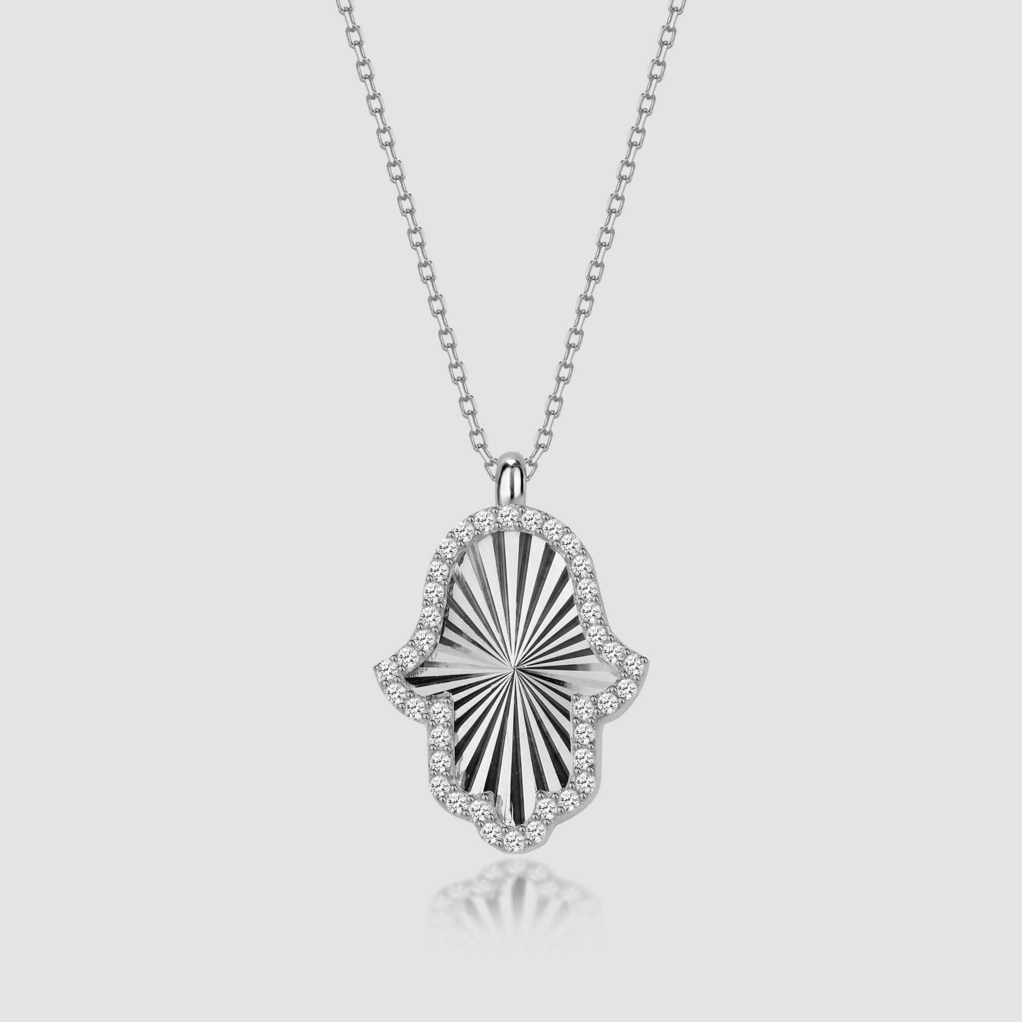 Silberne Hamsa Hand Halskette mit Zirkonia, Shiny Collection von Dkeniz auf hellem Hintergrund.