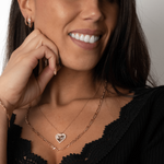 Frau trägt Heart Shiny Collection Kette in Roségold im Layering-Look zu schwarzem Oberteil.