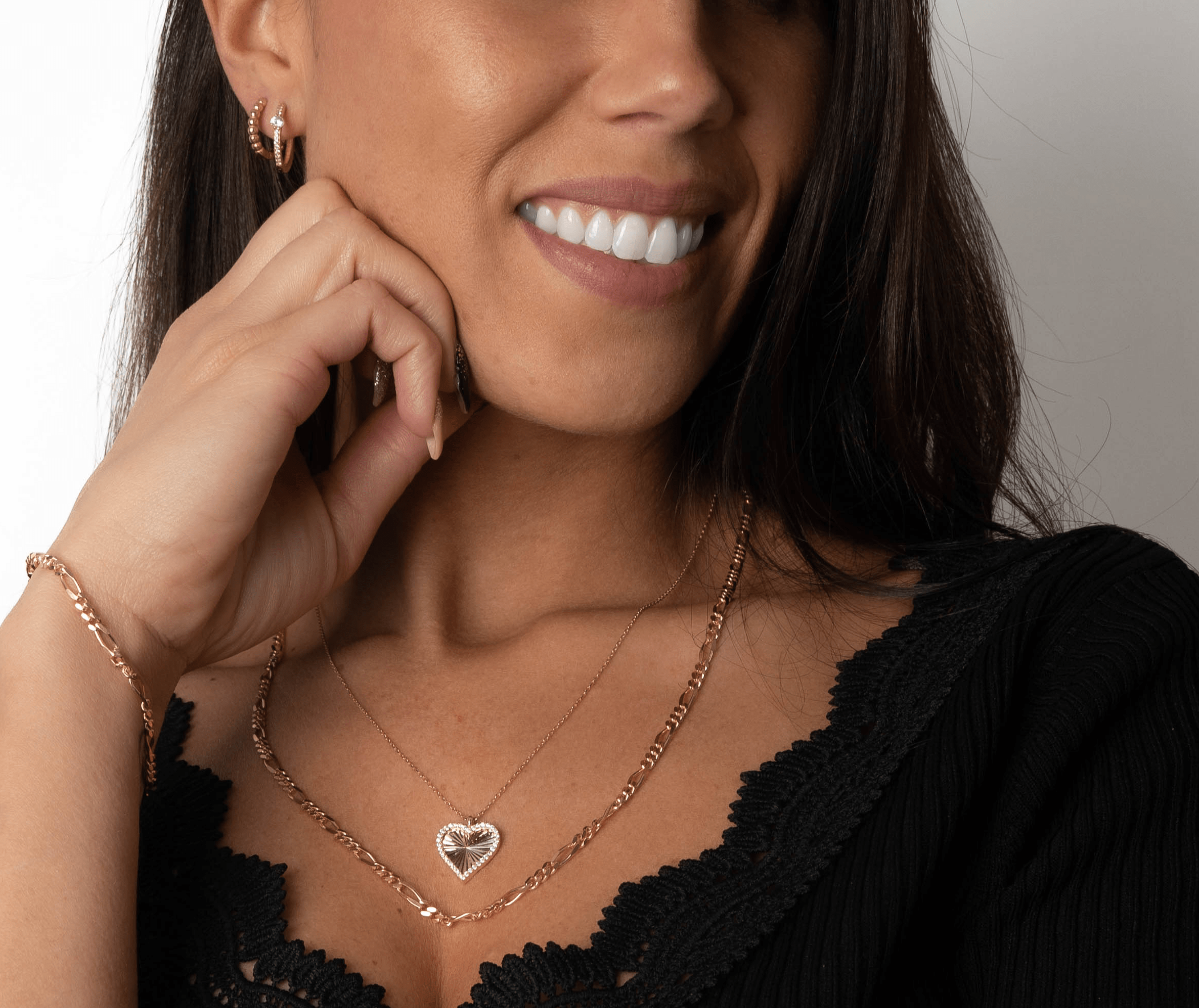 Nahaufnahme einer Frau mit Heart Shiny Collection Herz-Kette und passendem Roségold-Schmuck.