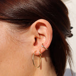 Kleine goldene Creolen Classic Thin S am Ohr kombiniert mit weiteren Ohrringen.