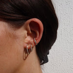 Funkelnde, dünne Hoop-Creolen M mit Zirkonia im Ear-Stack einer Frau.