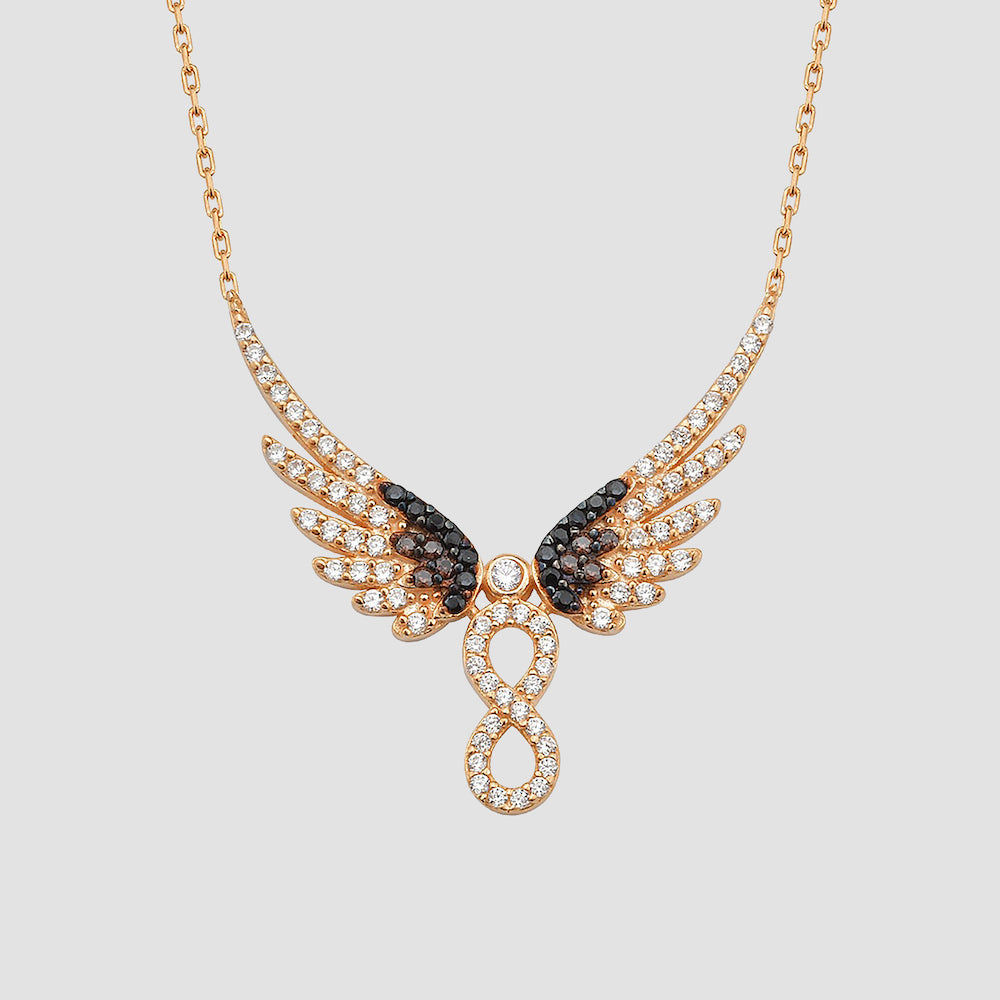 Infinity Angel Wings Halskette in Rosévergoldung mit weißen und schwarzen Zirkonia-Steinen auf hellem Hintergrund.