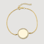 Mirror Gravur Armkette Gold mit runder Gravurplatte und Zirkonia-Rand auf hellem Hintergrund.