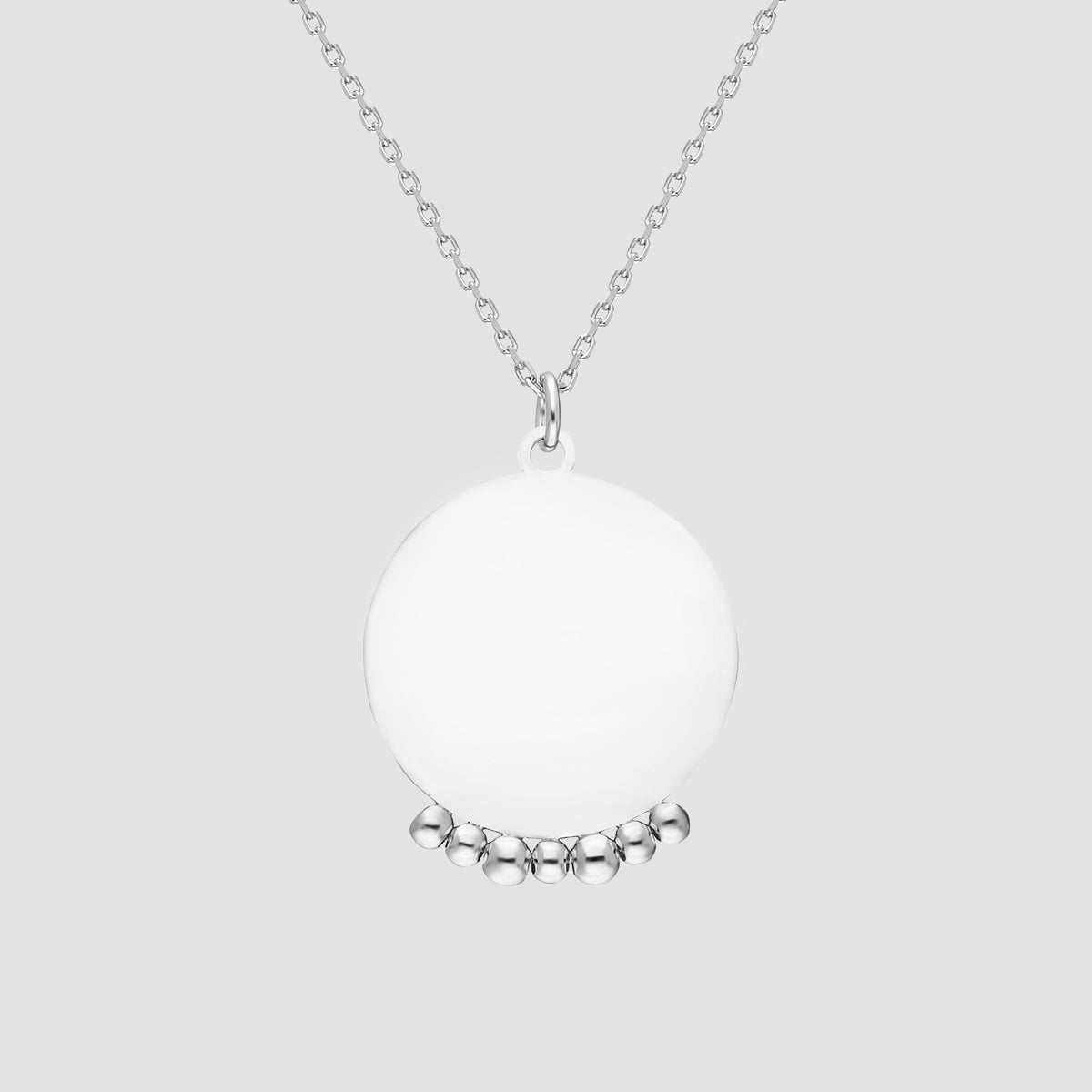 Mirror with Balls Halskette in Silber mit rundem Anhänger und Kugel-Details auf grauen Hintergrund.