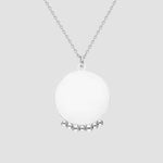 Mirror with Balls Halskette in Silber mit rundem Anhänger und Kugel-Details auf grauen Hintergrund.