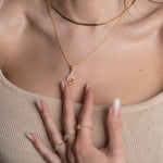 Notenschlüssel Kette Rosé & Silber als zarter Blickfang am Dekolleté, Styling mit Goldschmuck.