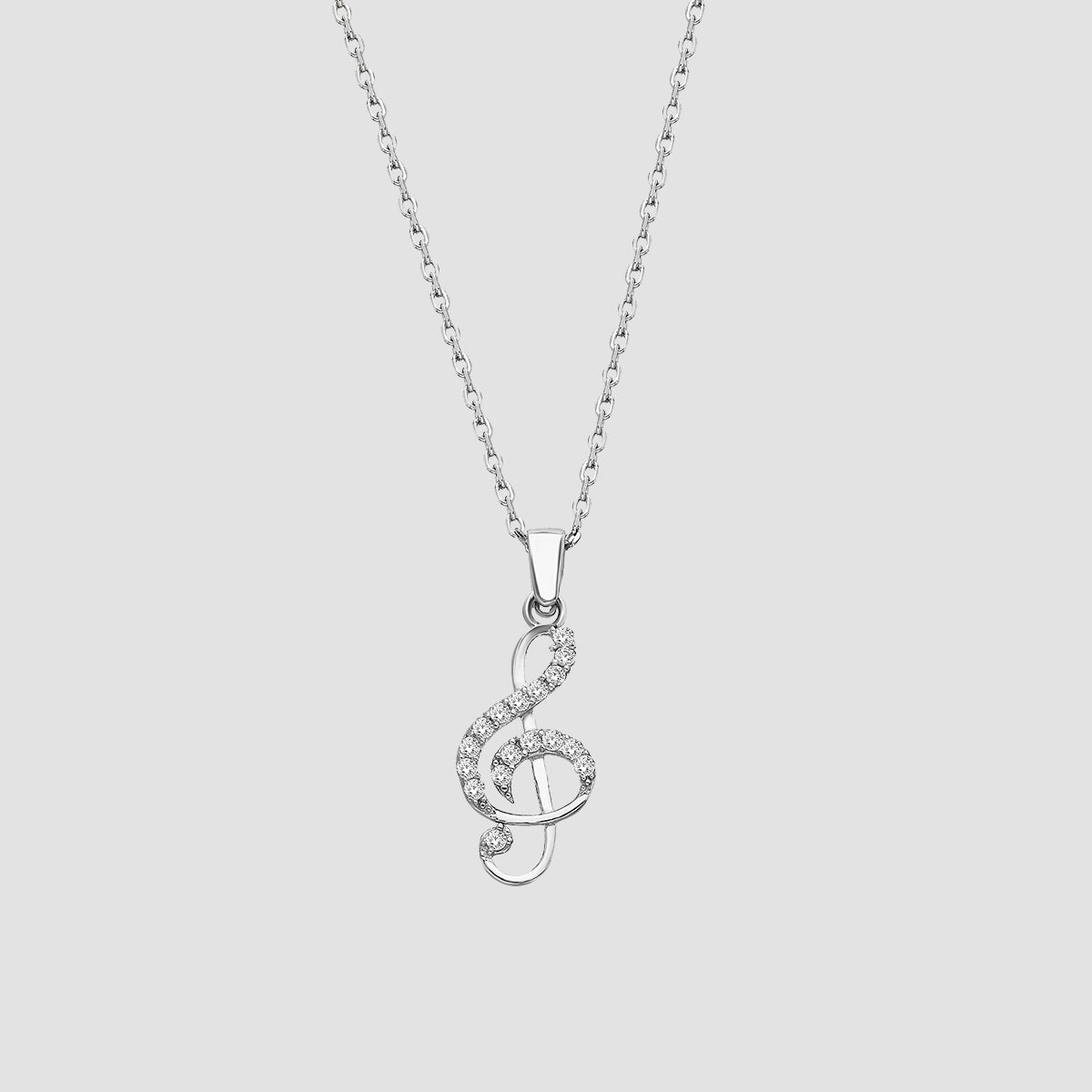 Feine Notenschlüssel Kette in Silber mit weißen Zirkonia-Steinen auf hellem Hintergrund
