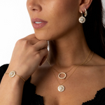 Model trägt Pearl X Baguette Halskette Gold im Layering-Look, eleganter Perlen- und Zirkonia-Anhänger.