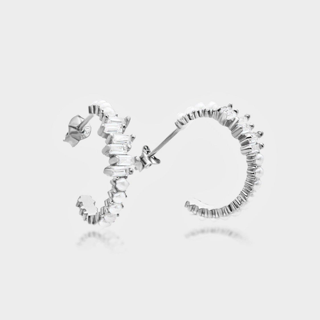 Pearl X Baguette Ohrringe aus 925 Silber mit Perlen und Zirkonia auf weißem Hintergrund.