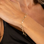 Zartes Plättchen Armband mit weißen Zirkonia in Gold am Handgelenk getragen – eleganter Damen Schmuck.