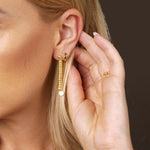 Am Ohr mit Hand: SHINY BALLS II Ohrringe Gold am Ohr, zartes Kugel-Design, minimalistisch und elegant.