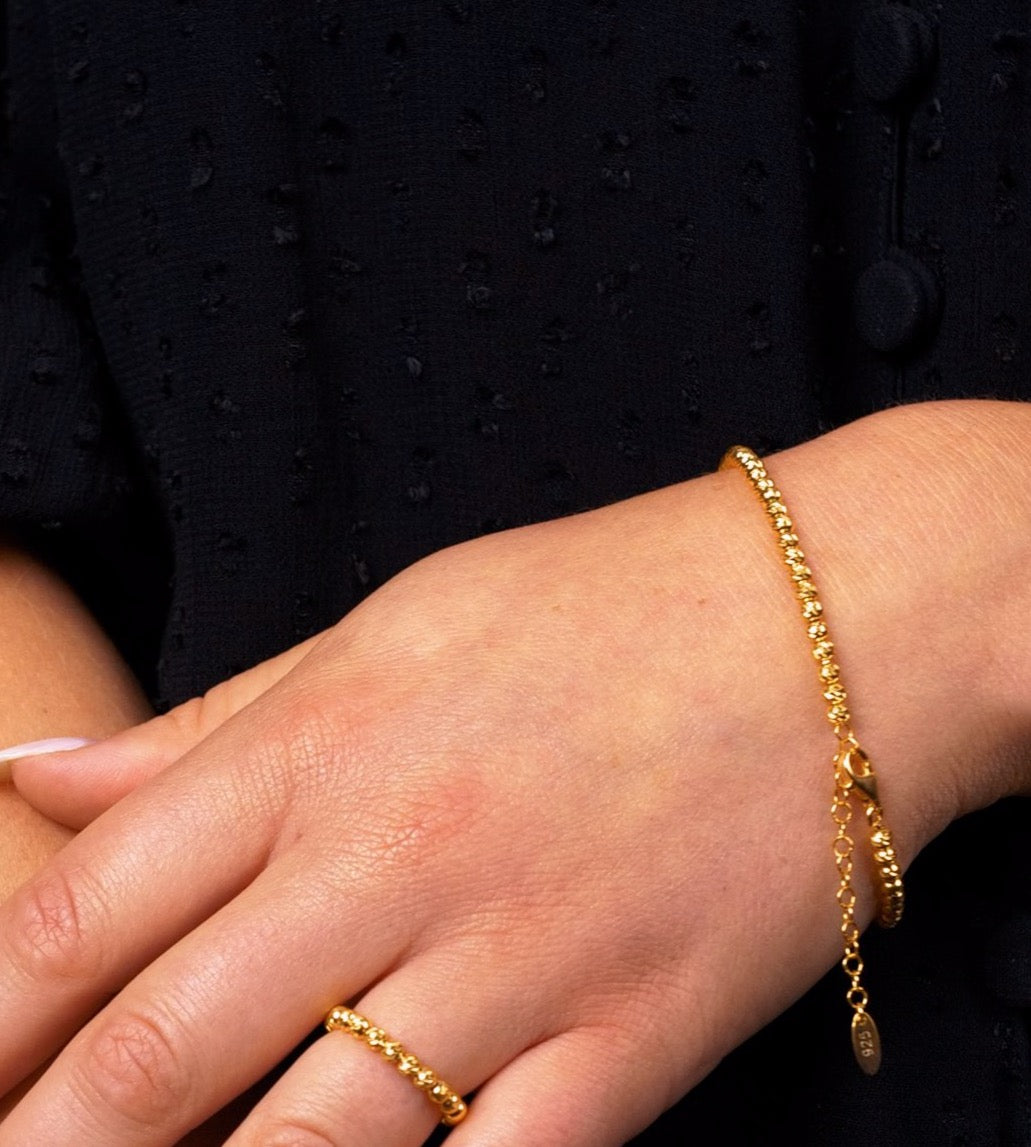 SHINY BALLS X Armkette Gold am Handgelenk getragen – feines, glänzendes Kugelarmband mit Verlängerung.