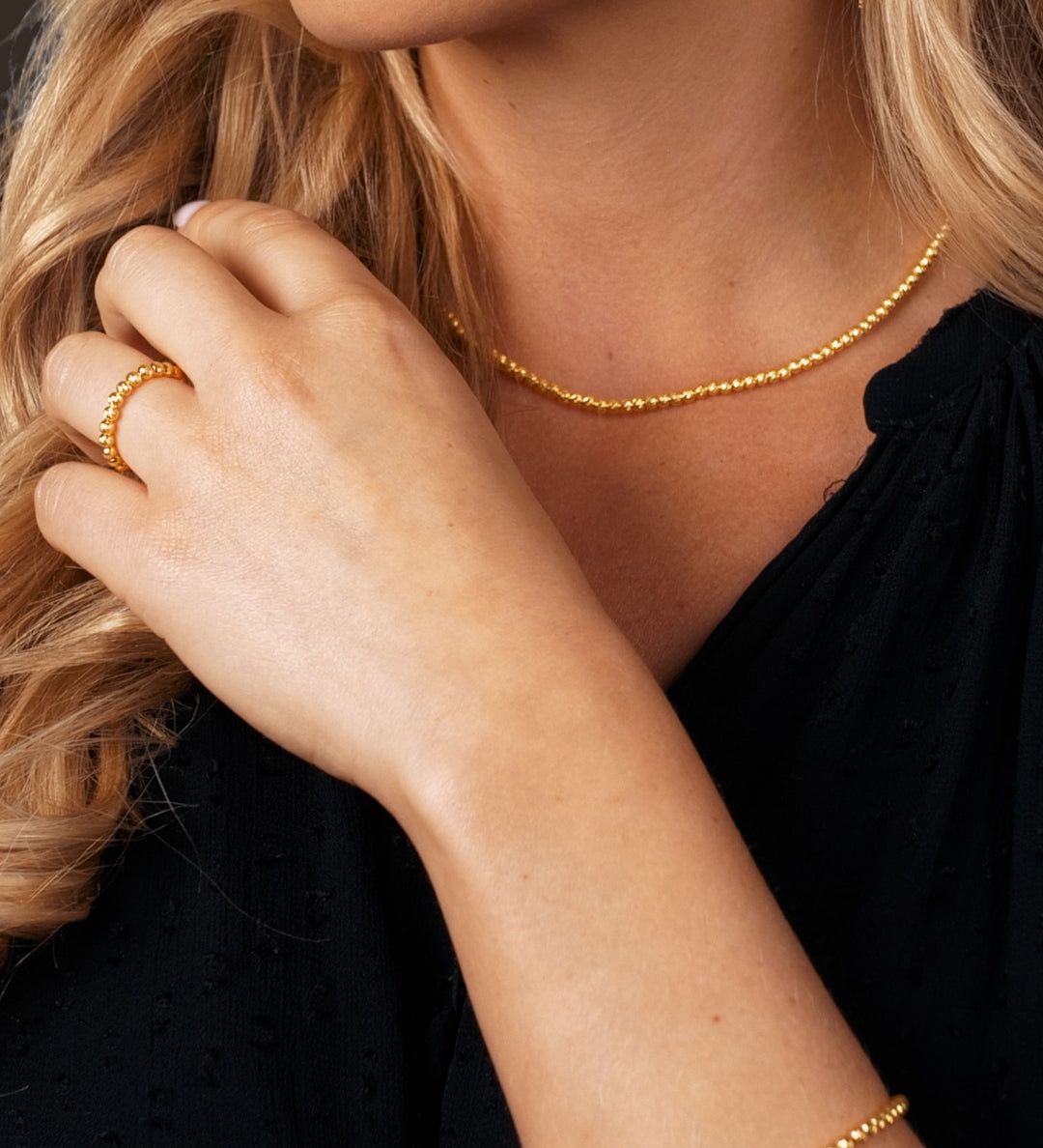 Model trägt SHINY BALLS X Ohrringe Gold – elegante, lange Bügelohrringe, glänzende Kugel-Optik.