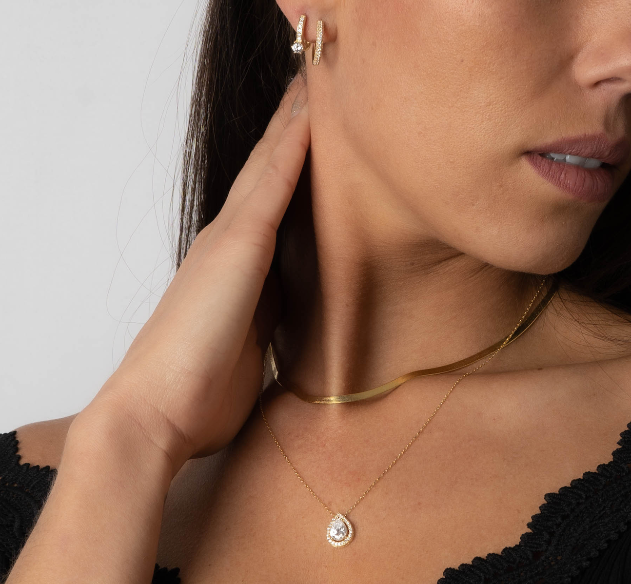 Seitliches Model mit Sleek Halskette Gold und Anhänger-Kette, eleganter Layering-Look.
