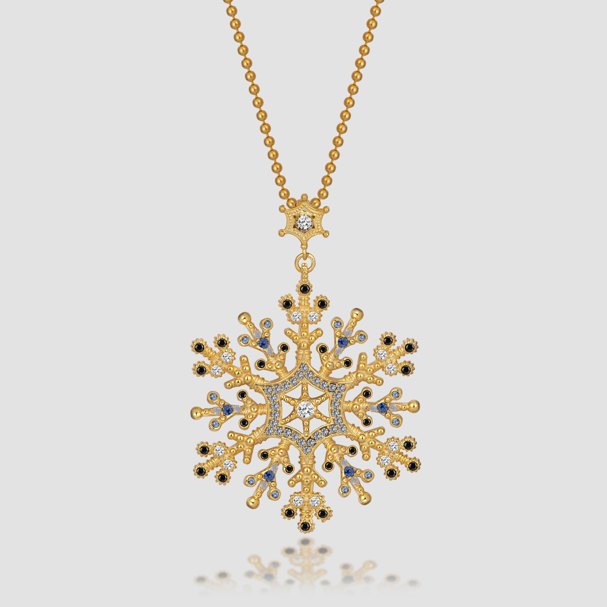 Snowflake Ice Halskette in Gold mit Schneeflocken-Anhänger und Zirkonia-Mix vor hellem Hintergrund.