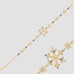 Snowflake Ice X Armkette Gold aus 925 Sterling Silber mit Zirkonia-Mix, Detailansicht auf grauem Hintergrund.